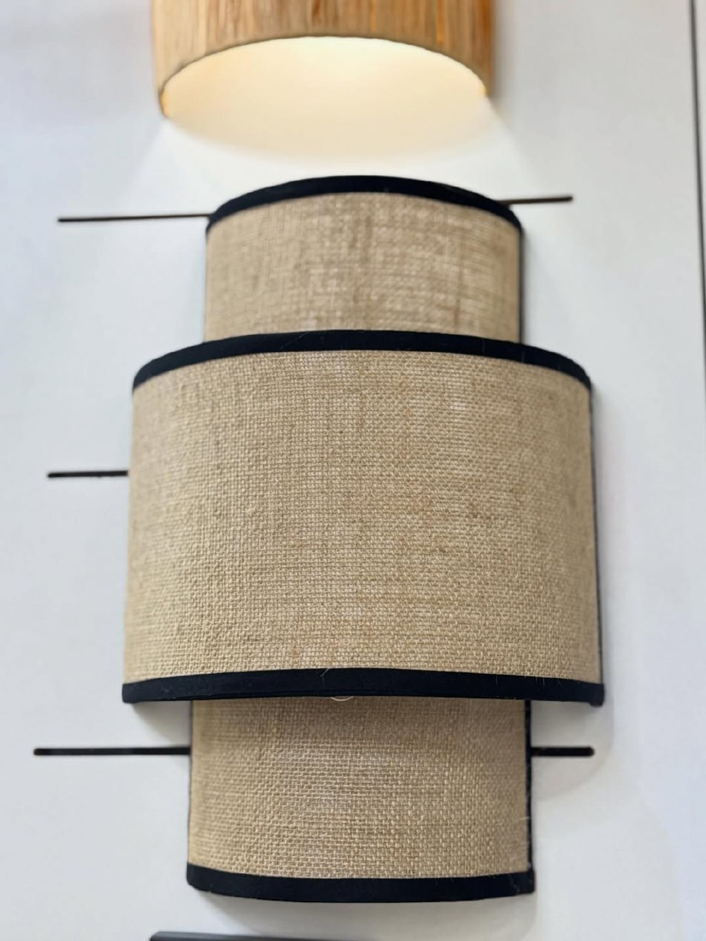 Стильное настенное бра с многоуровневым абажуром из натурального текстиля.