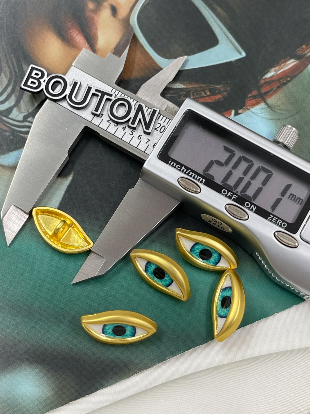 Пуговицы Скиапар. золотистые в форме "Глаза" с голубым (бирюзовым) зрачком
