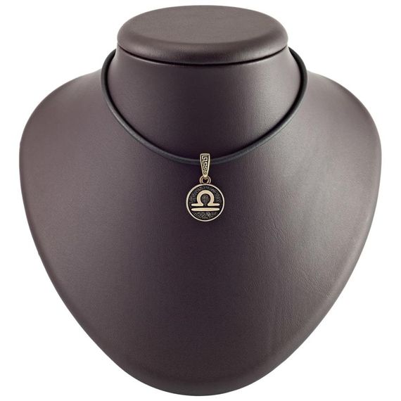 Фото бронзовой подвески знак зодиака Весы на постаменте.