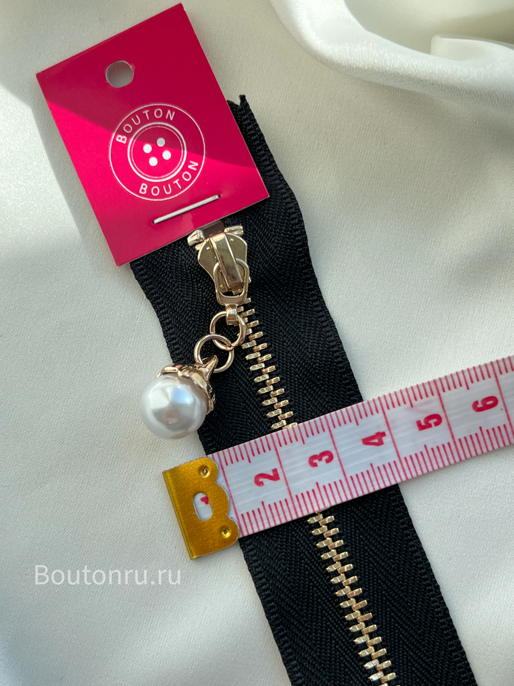 Молния черная с жемчужиной в обрамлении ажурного золотистого металла
