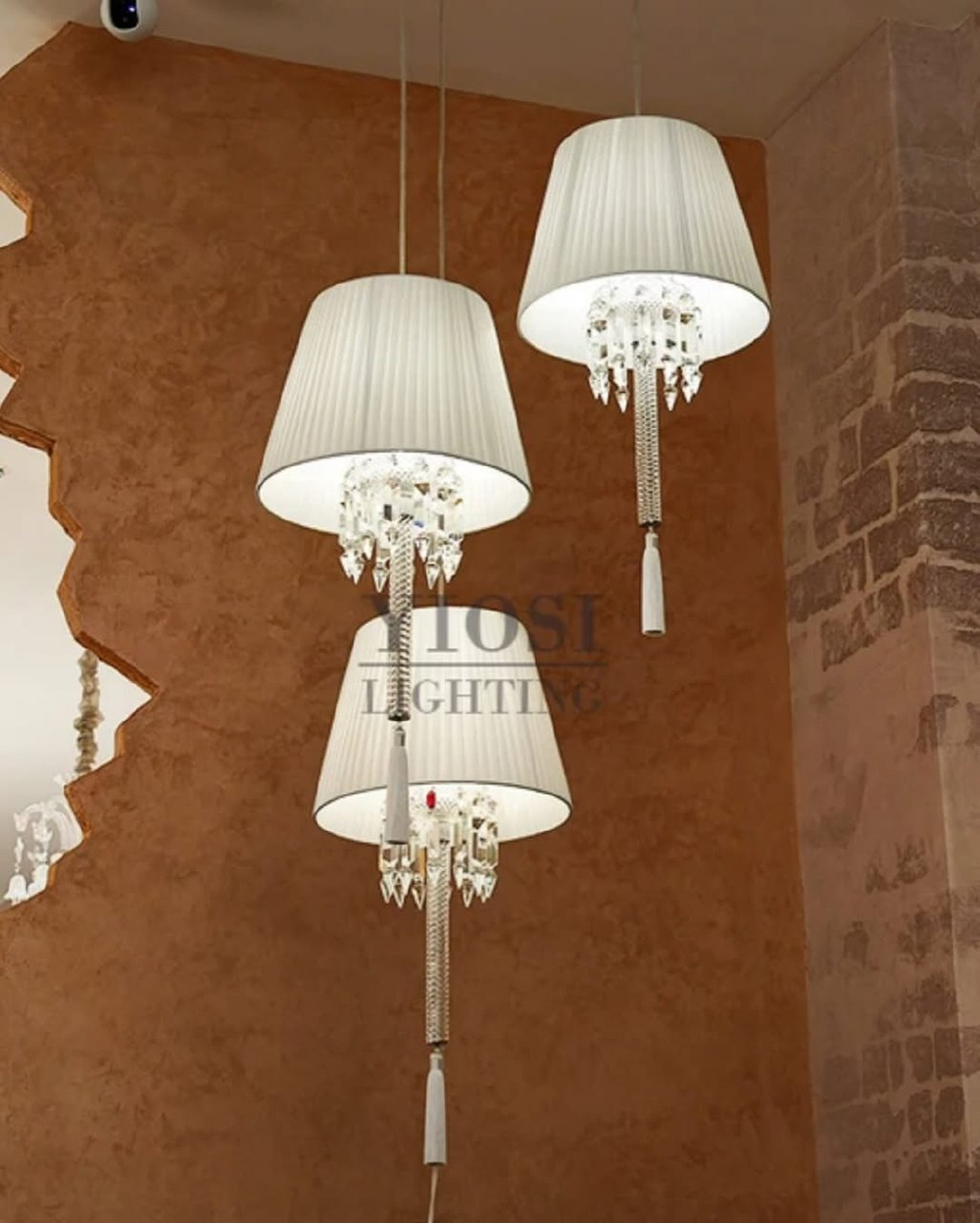 Изысканное люстра Baccarat с белым плиссированным абажуром, хрустальной ножкой и акцентной красной кистью.