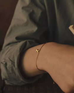 браслет «мятый лист» из желтого золота на бежевой нити