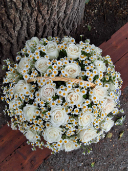 Композиция в корзине из белых роз и полевых ромашек