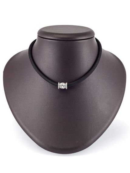 Фотография шарма Уруз из серебра 925 пробы на постаменте.