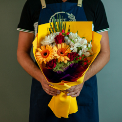 Яркий букет в желтой цветовой гамме с герберами и красными розами