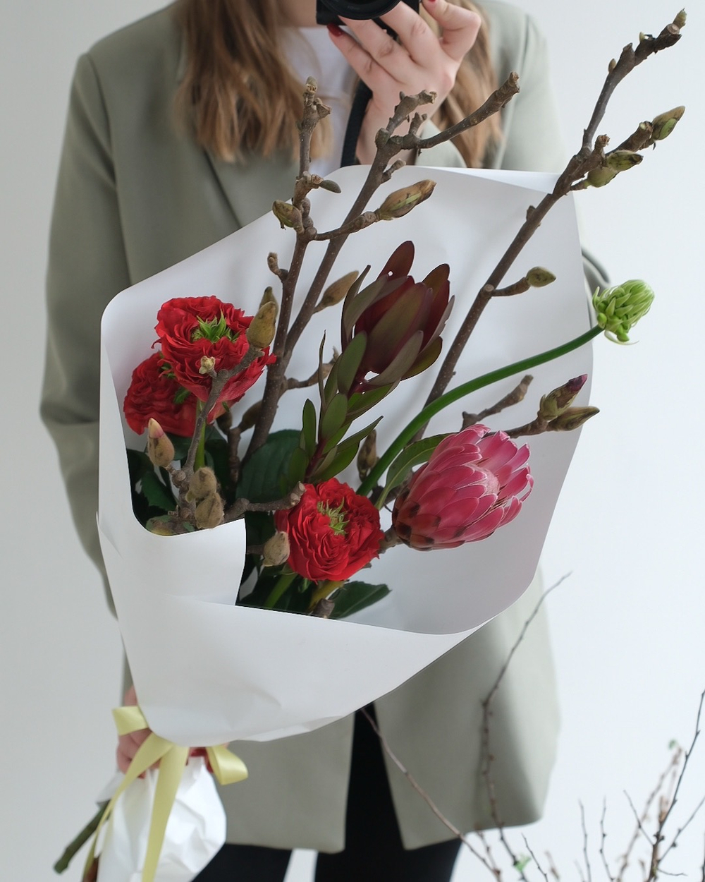 Букет с ветками магнолии, протеей и пионовидными розами Ред Монстр