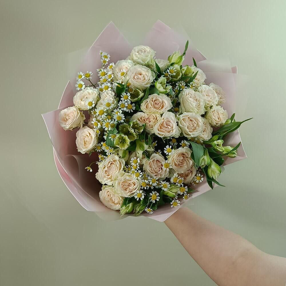 Нежный букет с кремовыми кустовыми розами, альсромериями и полевыми ромашками в упаковке