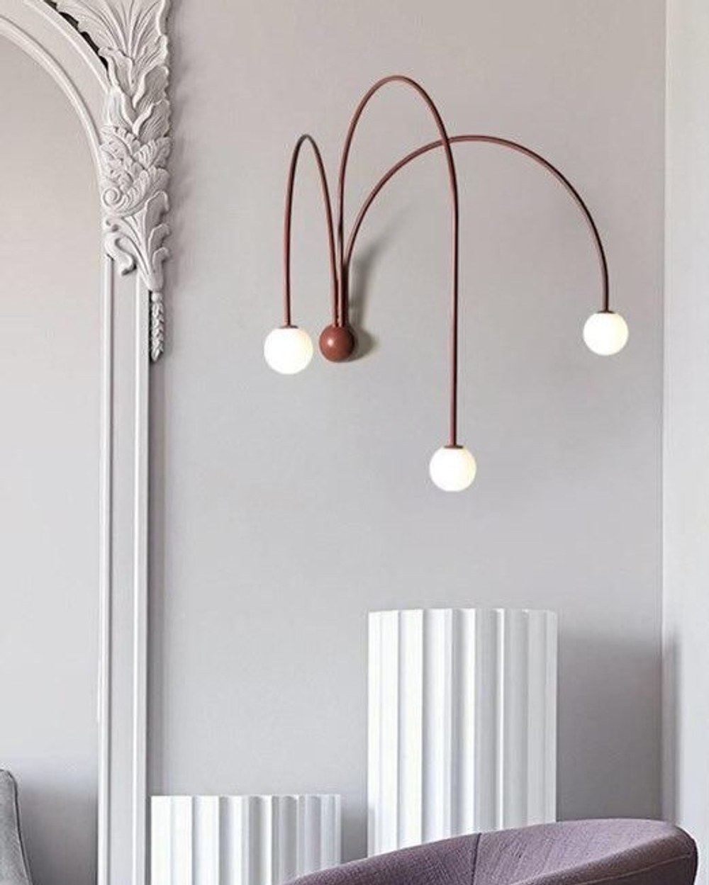Стильное настенное бра с изящными дугообразными держателями и матовыми шарообразными плафонами.
