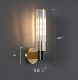 Элегантное настенное бра с вытянутым хрустальным плафоном и металлическим корпусом в тёплом золотом оттенке.