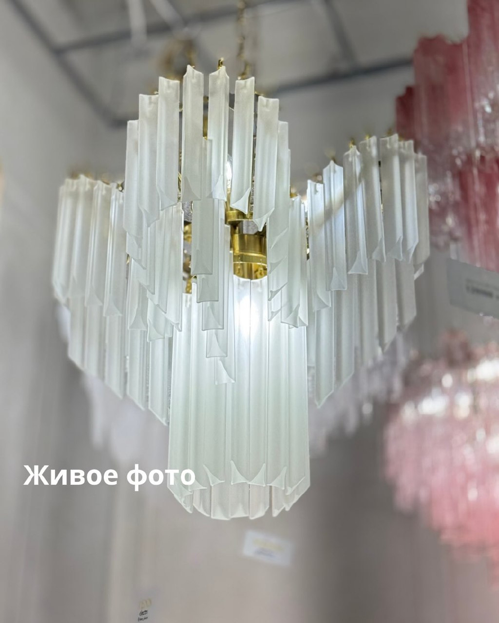 Изысканная каскадная люстра с вытянутыми стеклянными элементами и декоративной потолочной розеткой.