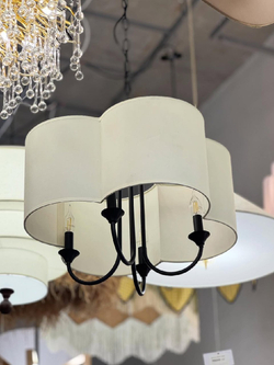Элегантная люстра с текстильным абажуром в светлом оттенке и черным металлическим основанием.