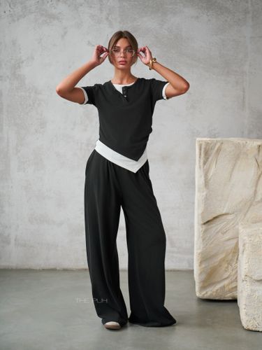 Трикотажный черный костюм с асимметричным топом