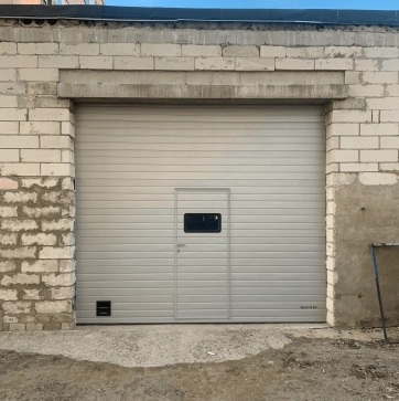 Секционные гаражные ворота с калиткой и окном в сером цвете