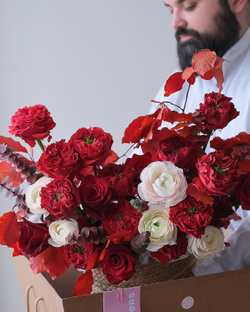 Романтичная композиция с ранункулюсами и пионовидными розами Ред Монст в большой корзине