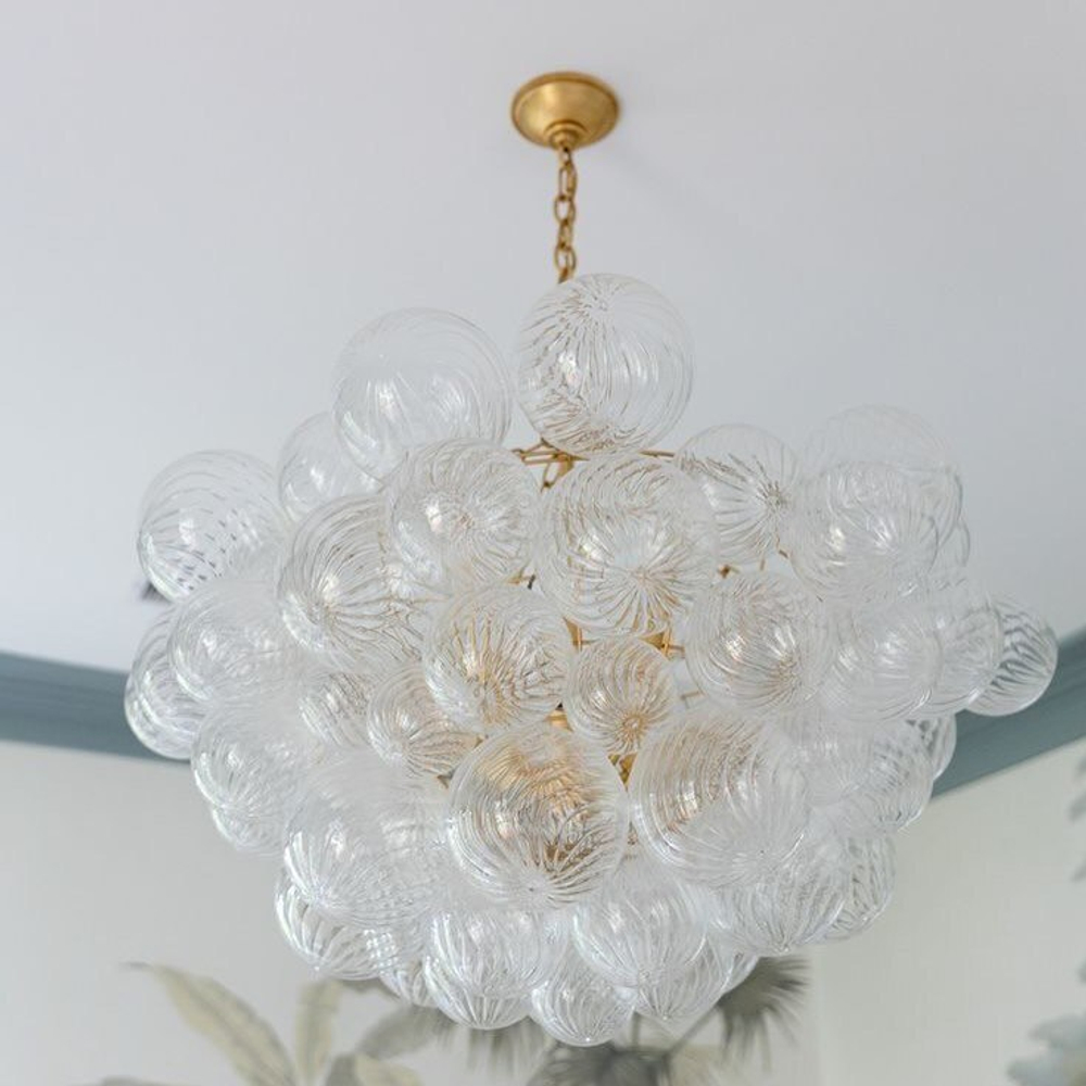 элегантная подвесная люстра в виде шара из прозрачных стеклянных плафонов.