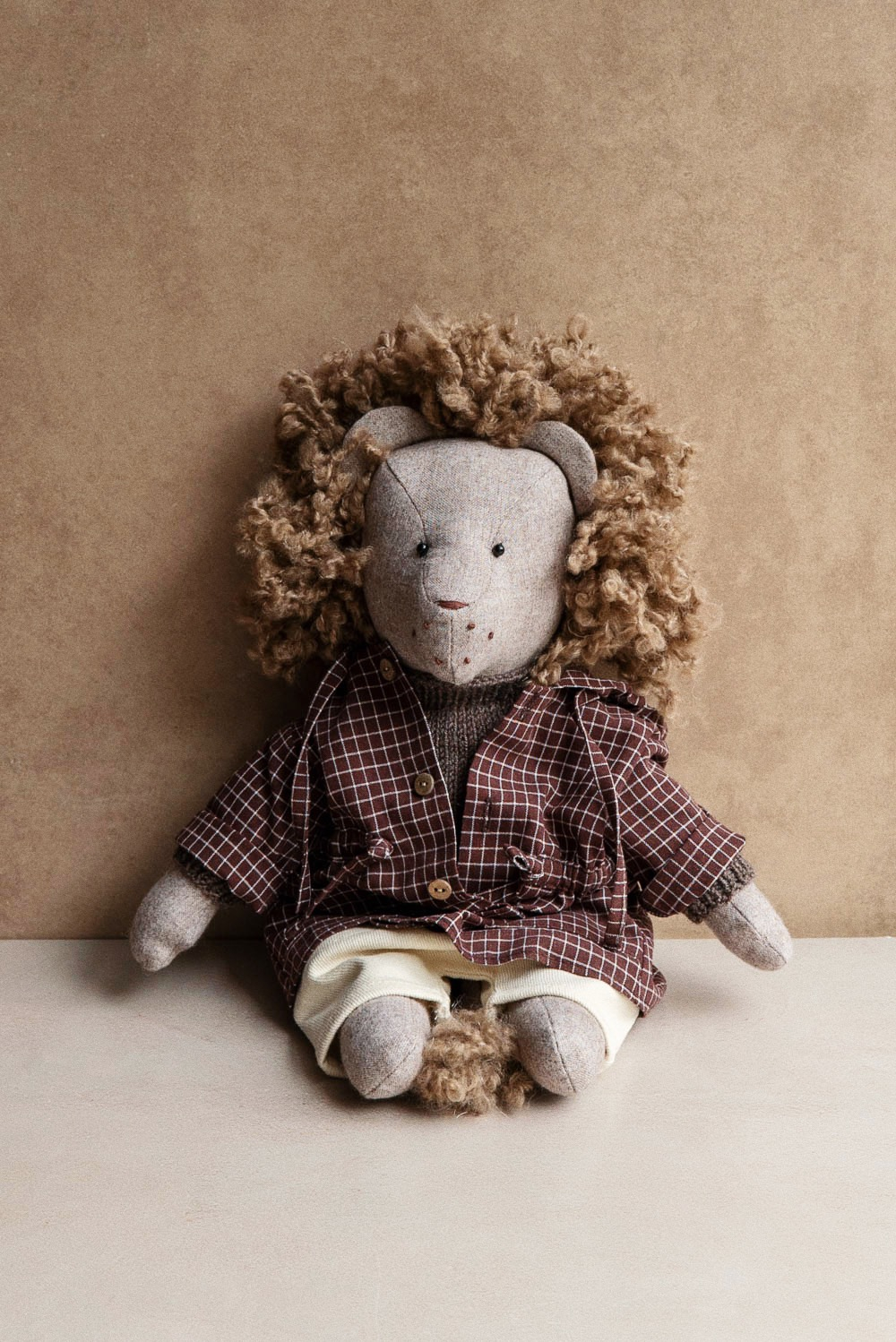 Лев бежевый в клетчатой парке