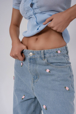 Джинсы широкие , голубые ,с нашивками в виде цветков .