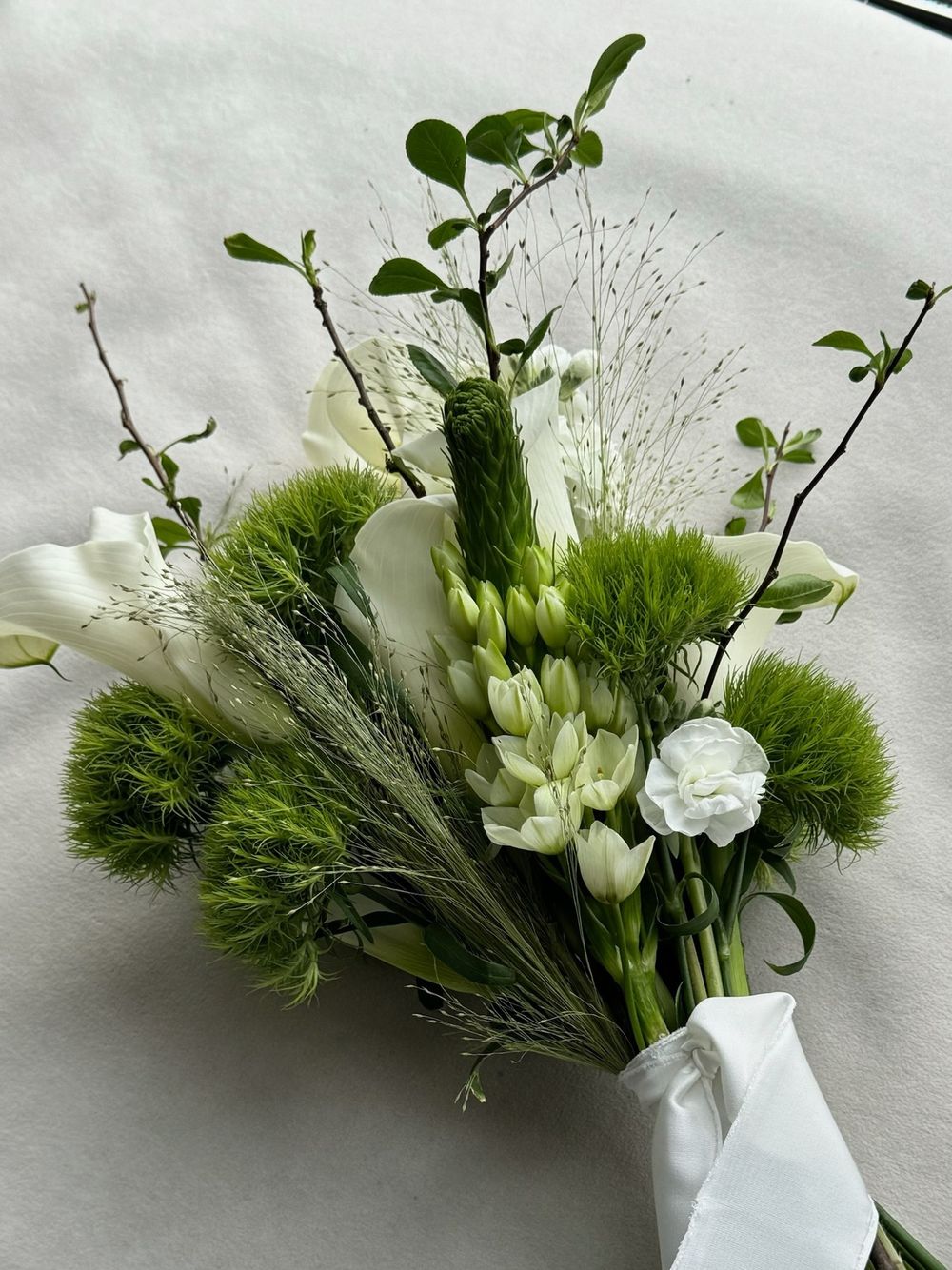 Свадебный букет из диантусов, орнитогалума, паникума, маттиолы и калл