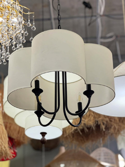 Элегантная люстра с текстильным абажуром в светлом оттенке и черным металлическим основанием.