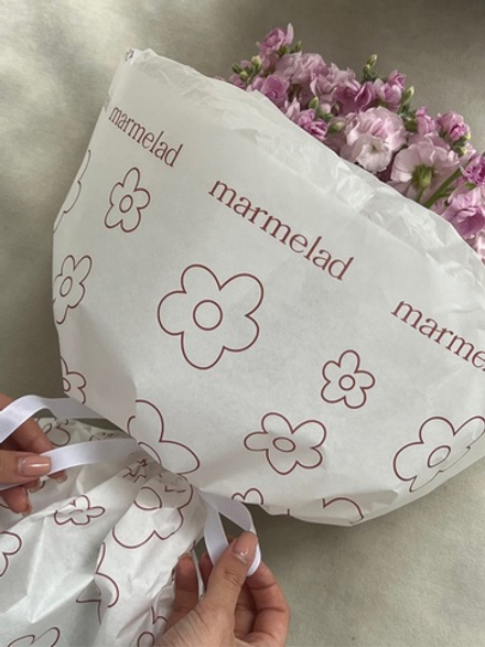 Упаковка букета в фирменную бумагу с розовым лого в цветочек