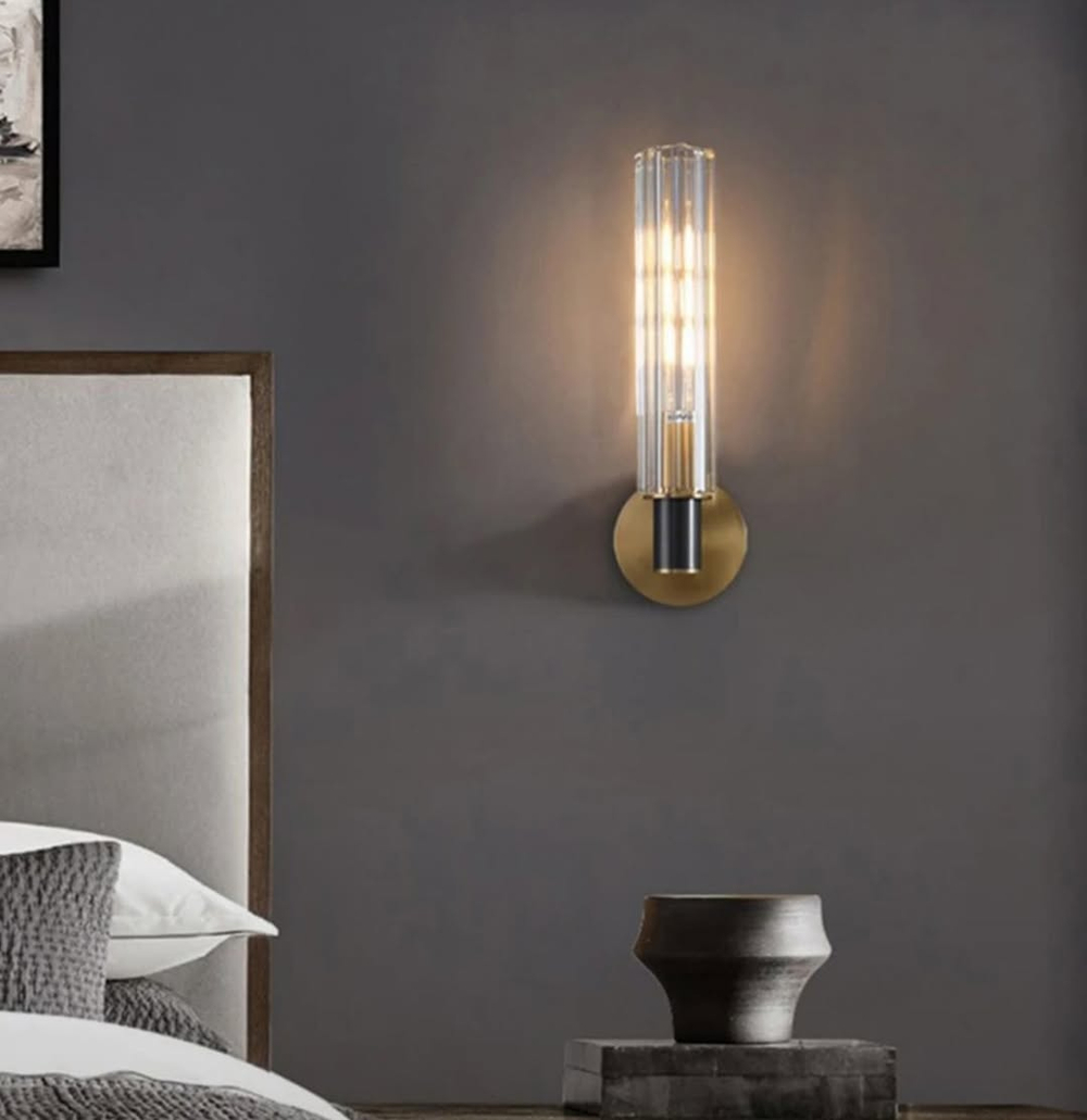 Элегантное настенное бра с вытянутым хрустальным плафоном и металлическим корпусом в тёплом золотом оттенке.