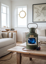 Интерьерный морской светильник WOODandROOT из судового фонаря 1957 года на деревянном столе в спокойной светлой гостиной.