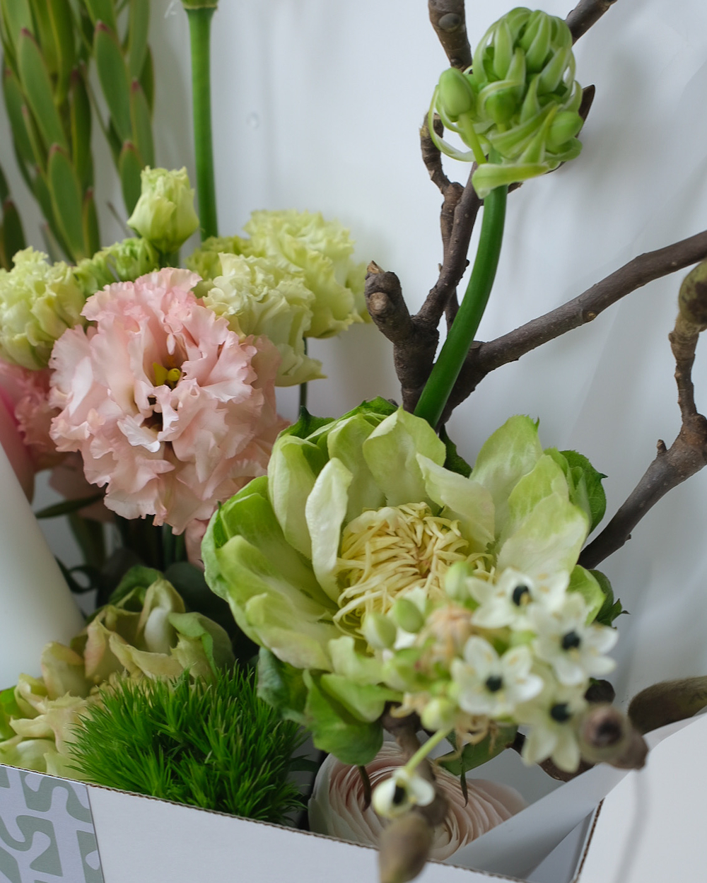 Букет с ветками магнолии, розами Вегги, нерине, орнитогалумом и ранункулюсами