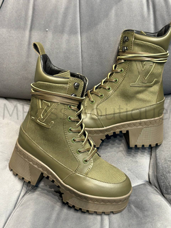 Demisezonnyye zhenskiye botinki Louis Vuitton desert boot (Lui Vitton) premium klassa tsveta khaki, na platforme Laureate, peredelana v polotnyanuyu versiyu s otdelkoy iz telyach'yey kozhi i shnurkami. Legkaya podoshva na platforme ukrashena ryadom initsialov LV, otsylayushchikh k okantovke istoricheskikh sundukov v vide rombov. Sboku model' podpisana bol'shim logotipom LV Initials.