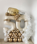 Бутылка шампанского на стойке с шарами