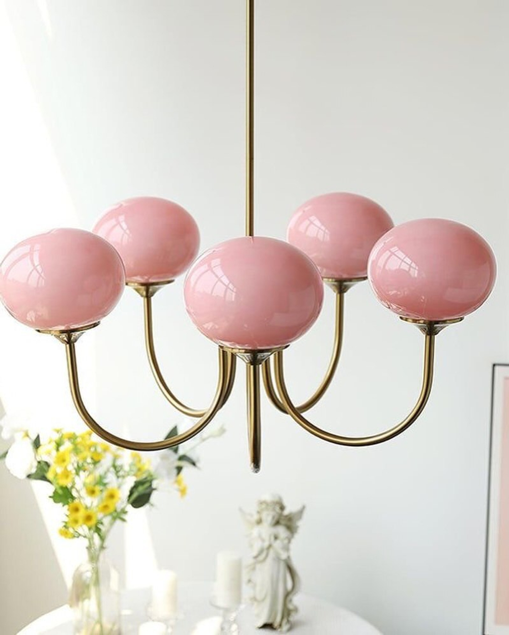 Элегантная люстра с глянцевыми розовыми плафонами и изящным золотым каркасом.