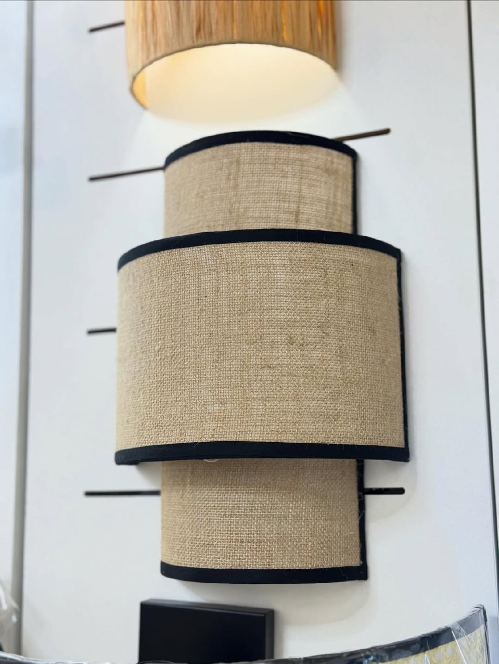 Стильное настенное бра с многоуровневым абажуром из натурального текстиля.