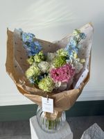 Букет из гортензии, дельфиниума, вибурнума, оксипеталума и лизиантуса