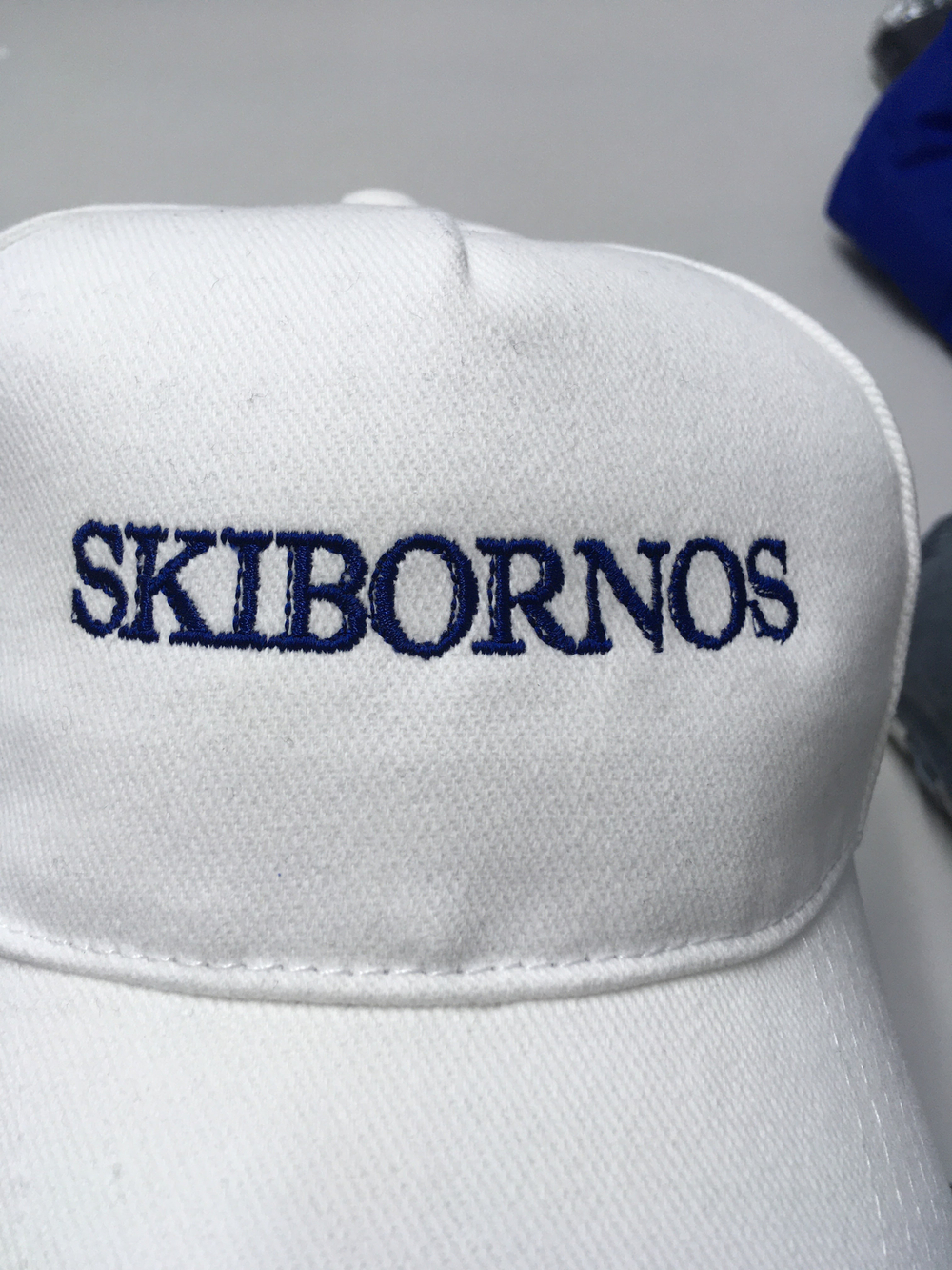 Белая бейсболка с синей надписью: SKIBORNOS