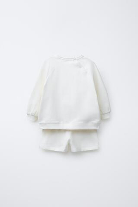 ZARA КОМПЛЕКТ ИЗ ТОЛСТОВКИ И ШОРТОВ С НАШИВКОЙ, ЖЕЛТОВАТО-БЕЛЫЙ