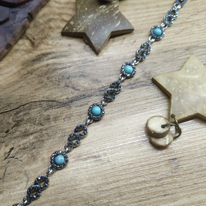 Браслет Vogue Восьмерка стразы графитовые круг бусина под бирюзу металл серебристый на красном бархате