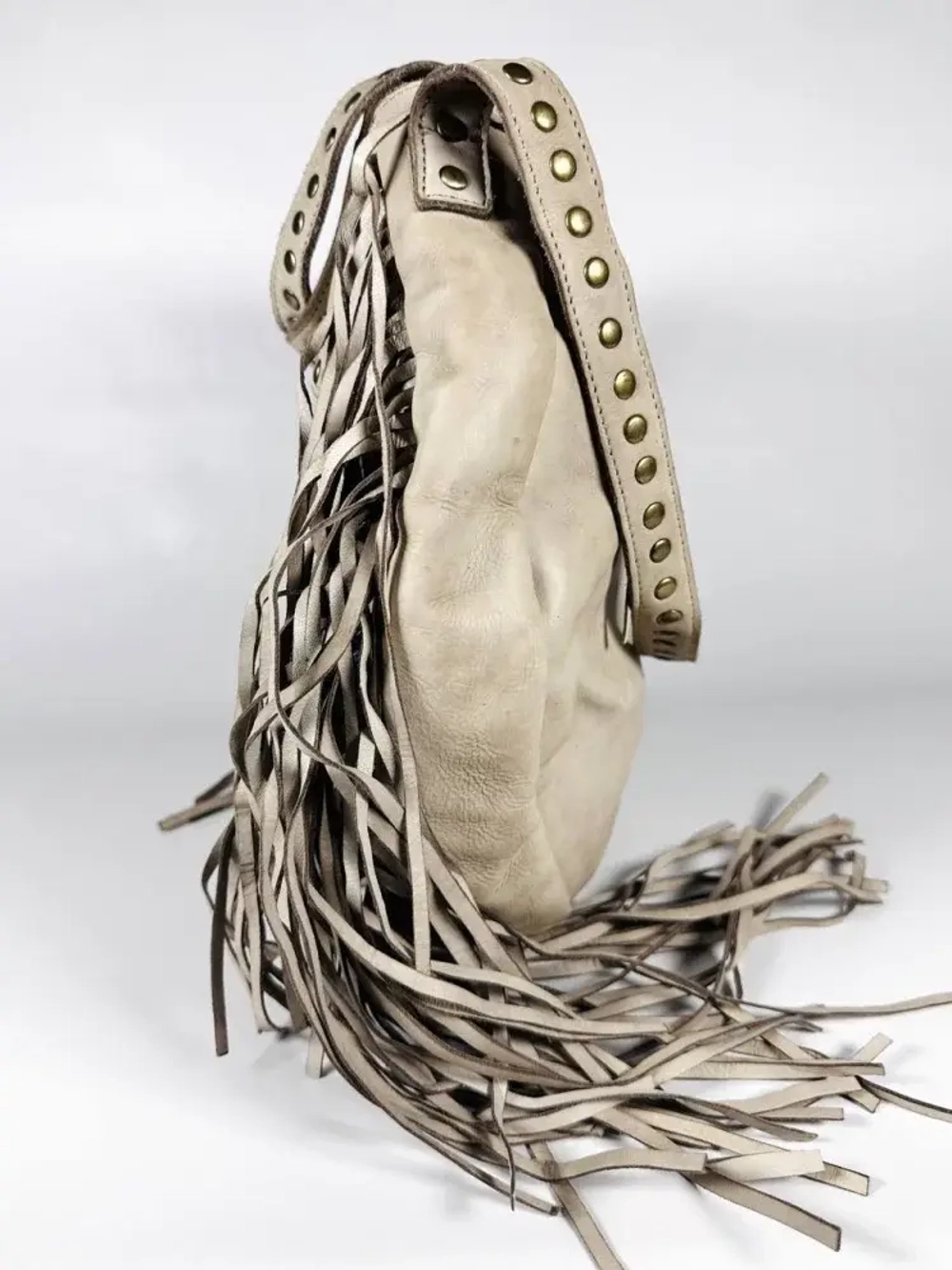 Женская сумка из натуральной вареной кожи с бахромой и заклепками цвет слоновая кость