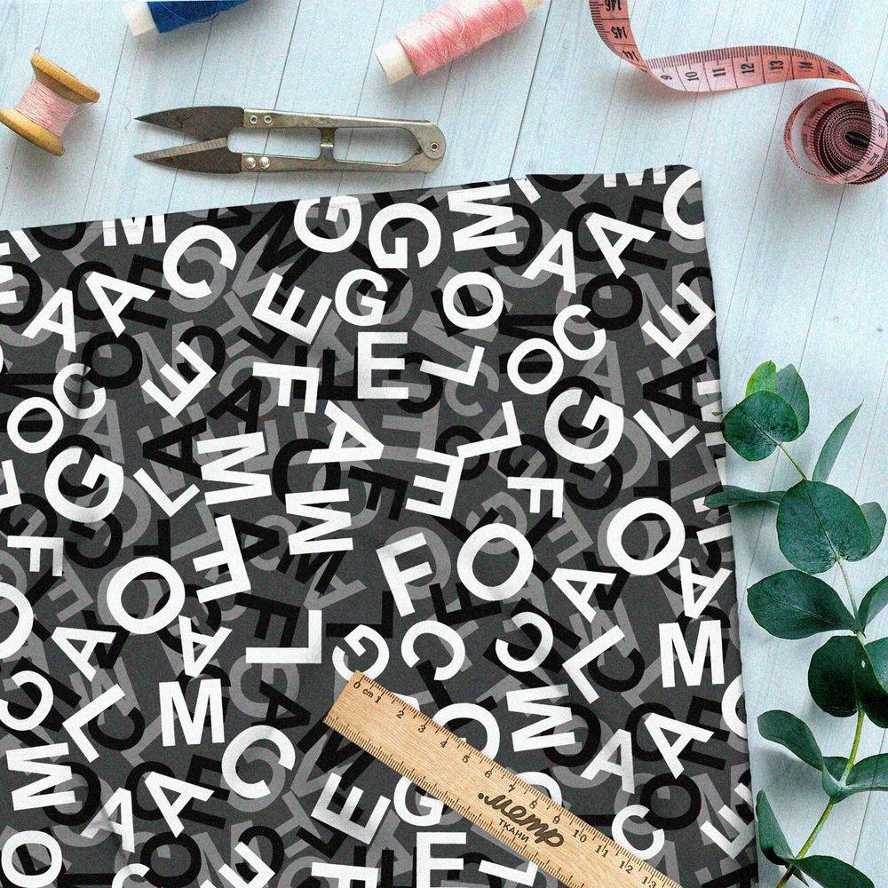 Ткань шифон хаос их букв на чёрном фоне