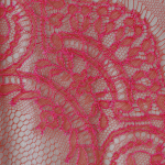 Широкая французская лента “Шантильи” с ажурным мотивом цвета фуксия на красном