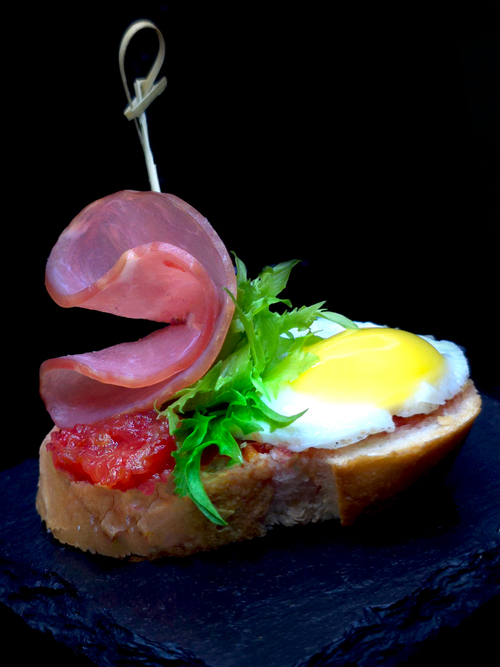 Брускетт с сыровяленой свиной вырезкой, перепелиным яйцом и аджикой