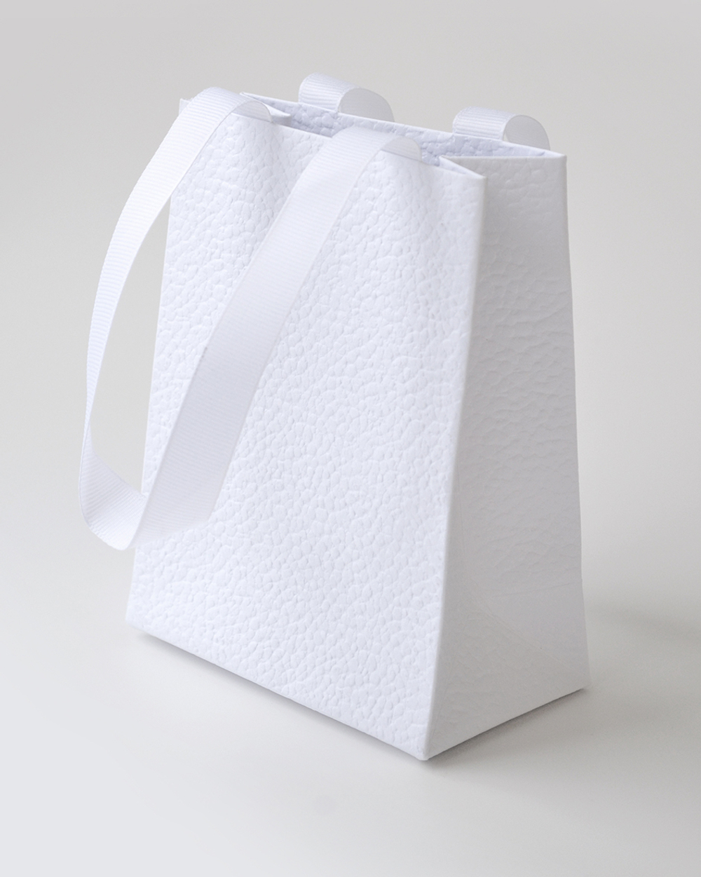 Подарочный пакет с репсовой лентой из дизайнерской бумаги.