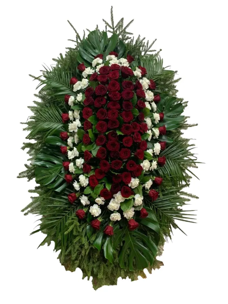 Венок из бордовых роз и белых гвоздик с зеленью и пальмовыми листьями