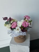 Композиция в коробке из кустовых пионовидных роз, хелеборуса, эвкалипта и лизиантуса