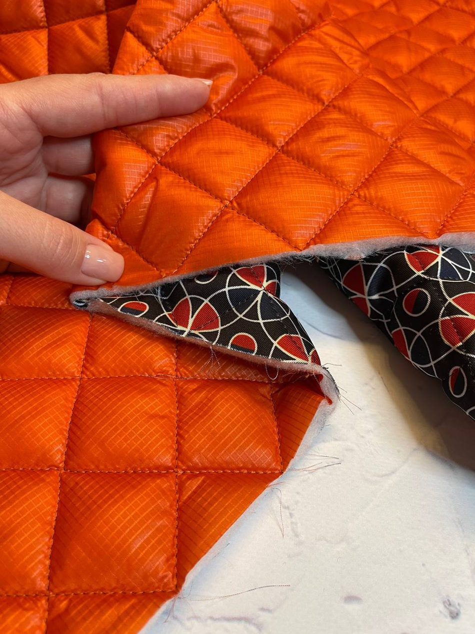 Двусторонняя курточная принтованная стежка с утеплителем и пропиткой на однотонной стороне (100%полиэстер/тенсулейт+90%вискоза/10%пэ, Апельсиновый оранжевый/геометрический принт на темном фоне, 137/139, 100 гр/м2)