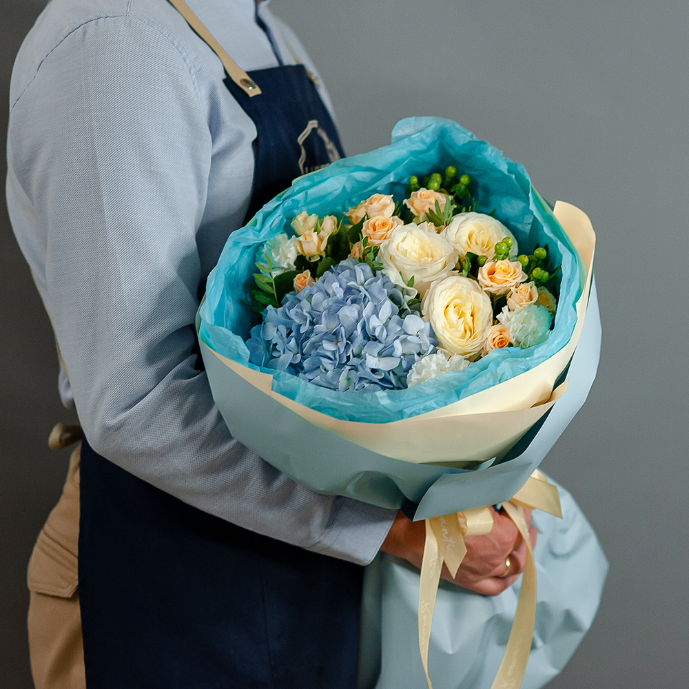 Пионовидные розы с голубой гортензией в стильном оформлении