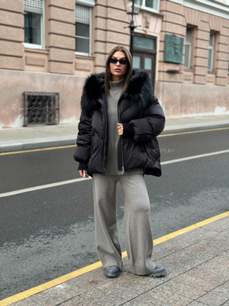 Черный пуховик с удлиненной спинкой и мехом енота