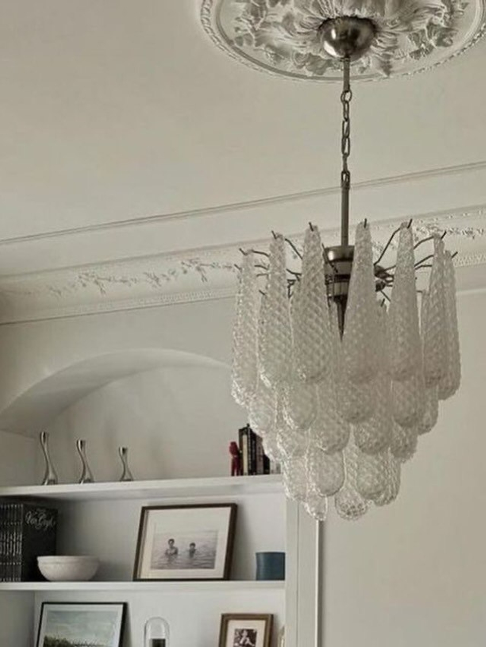 Элегантная подвесная люстра с металлическим каркасом и каскадом фактурных стеклянных плафонов.