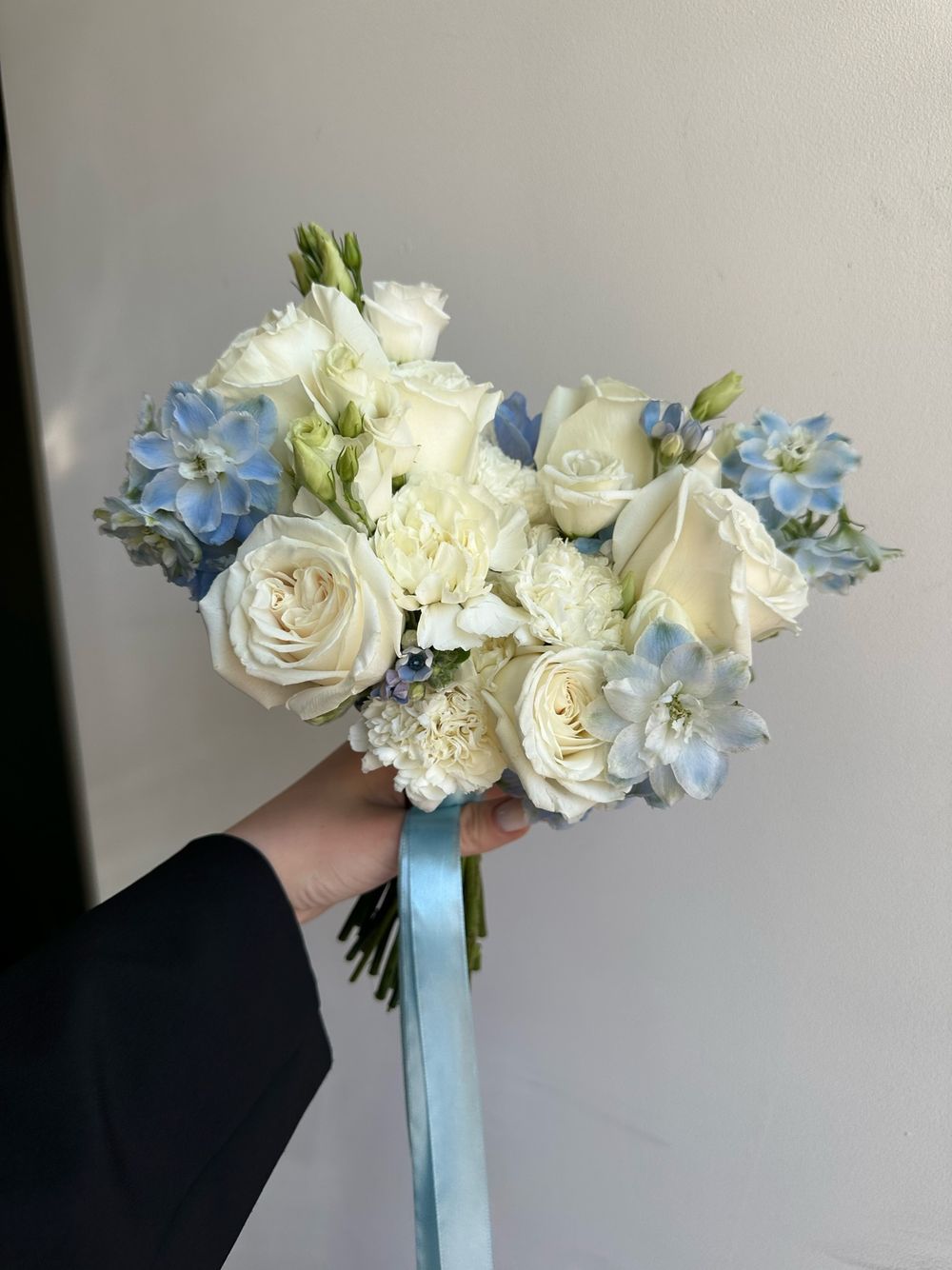 Свадебный букет из дельфиниума, одноголовых роз, оксипеталума и лизиантуса