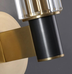 Элегантное настенное бра с вытянутым хрустальным плафоном и металлическим корпусом в тёплом золотом оттенке.