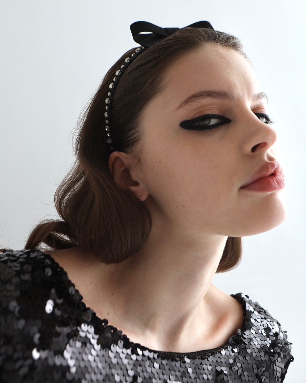 Тонкий ободок с бантом декорированный белыми камнями