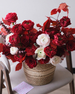 Романтичная композиция с ранункулюсами и пионовидными розами Ред Монст в большой корзине